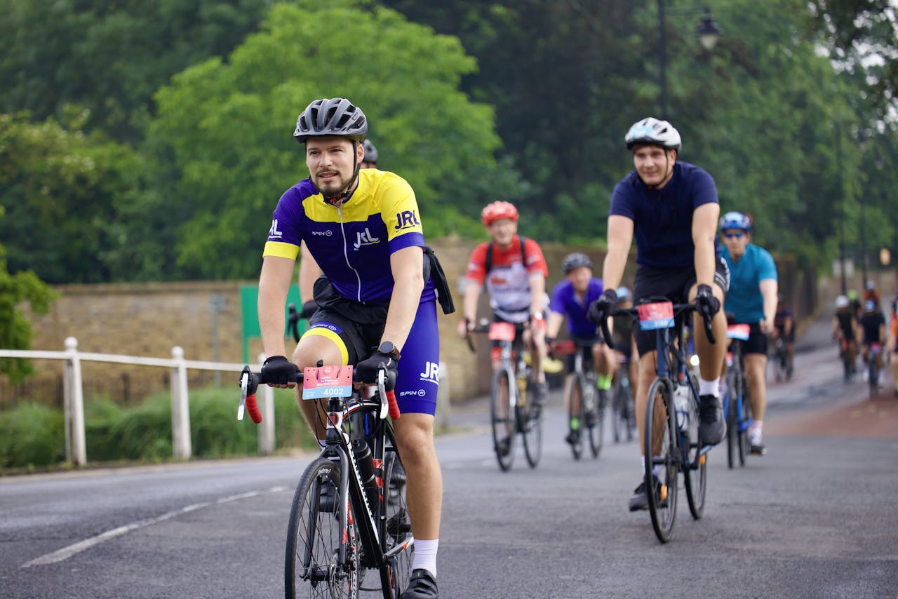 A group of people riding bicycles down a road